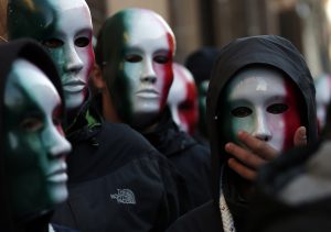 Members of Casapound far-right organization wear masks in the colors of the Italian flag before a demonstration organized by "People from pitchfork movement" to protest against economic insecurity and the government in downtown Rome December 18, 2013. Italy's "pitchfork" protests spread to Rome on Thursday when hundreds of students clashed with police and threw firecrackers outside a university where government ministers were attending a conference.  (Yara Nardi/Reuters)