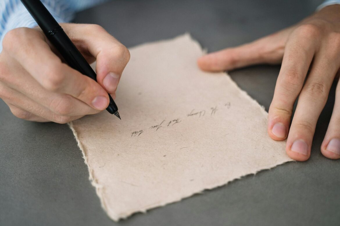 close up shot of a person writing on a paper