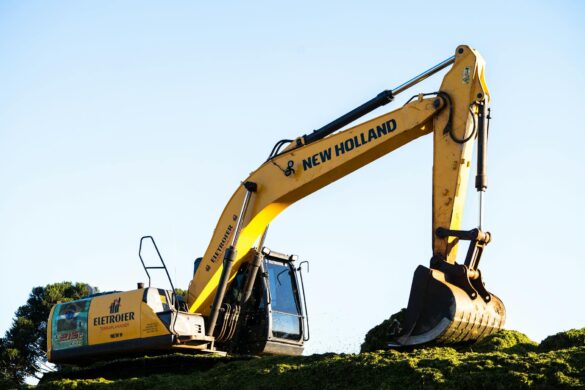 a yellow excavator is sitting on top of a hill
