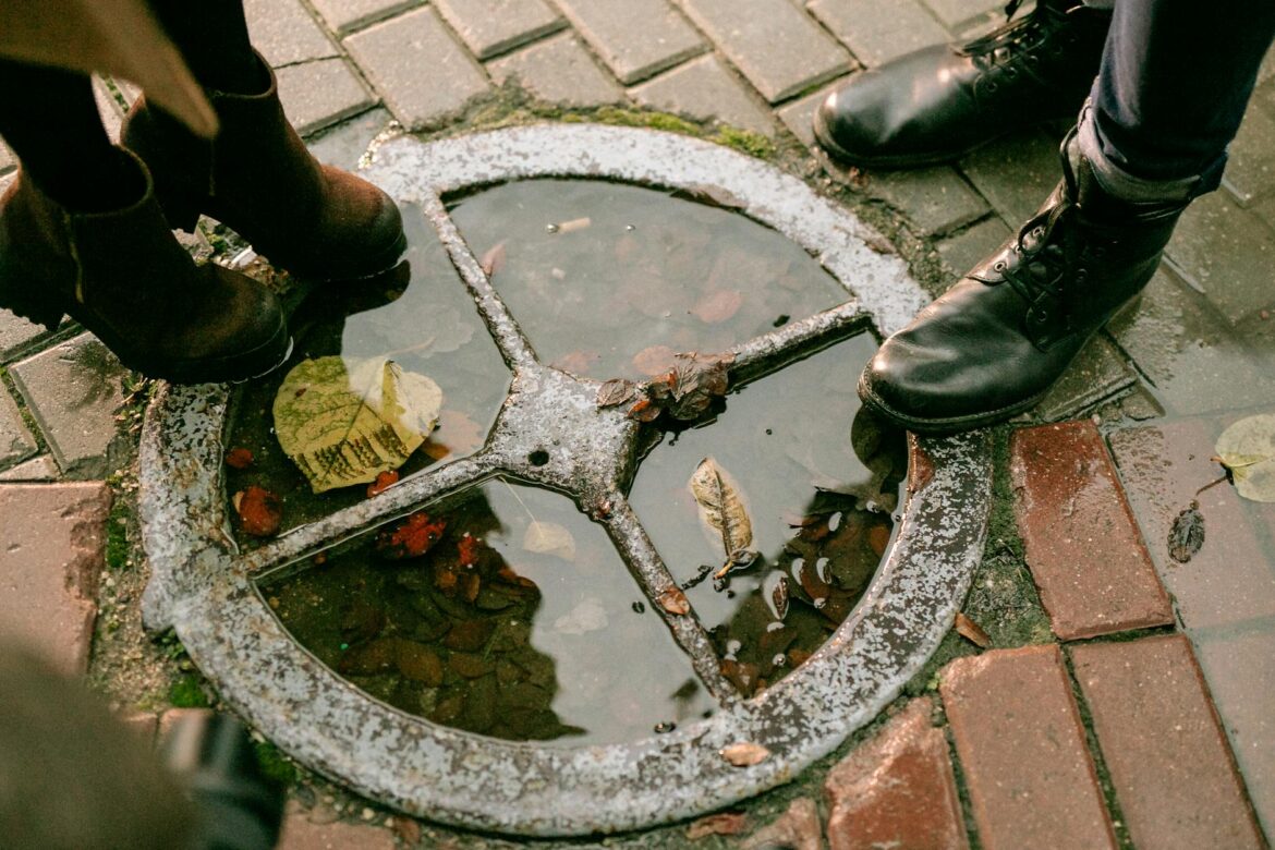 close up of people legs standing on hatch after rain