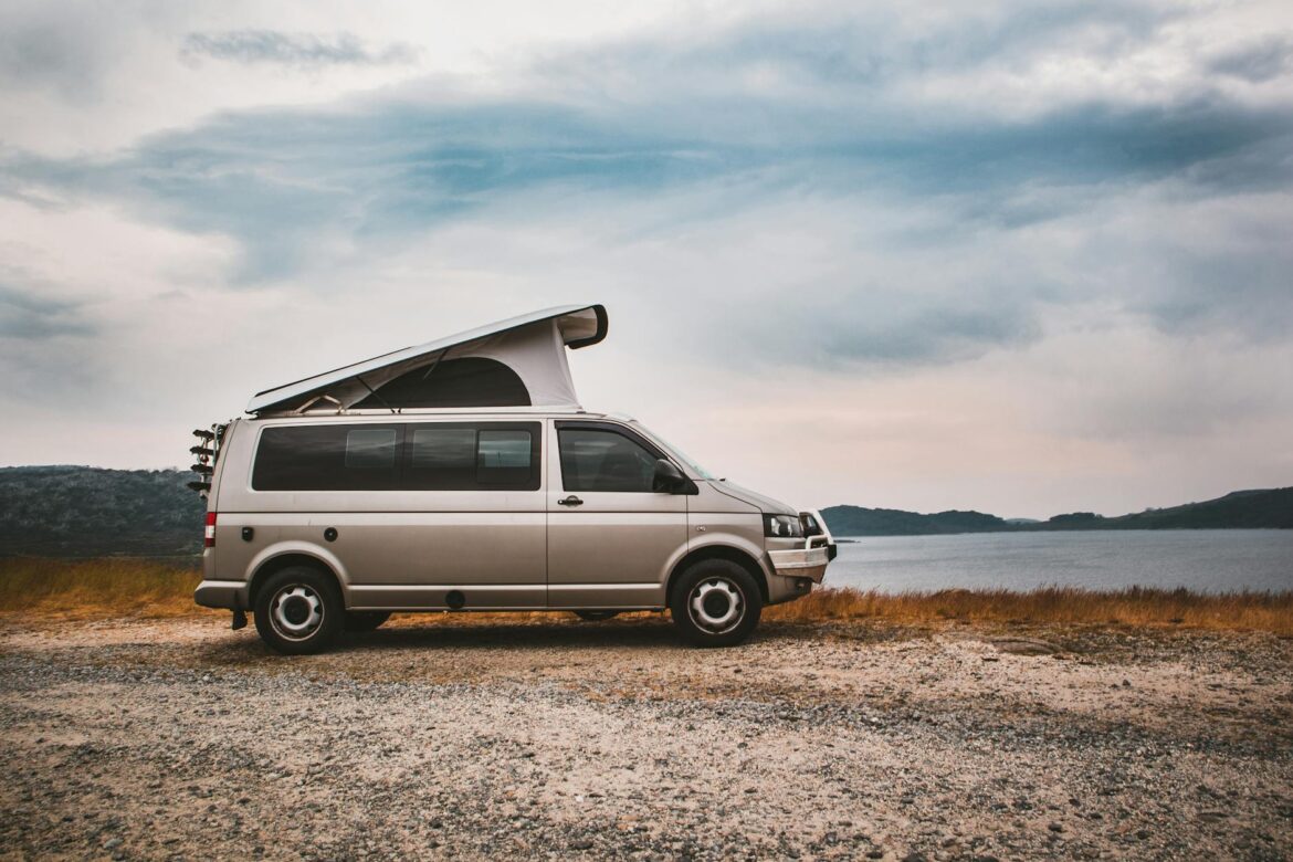 white van on brown field under white clouds