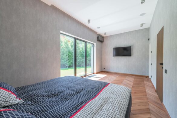 a cozy bed surrounded with concrete walls with sliding door