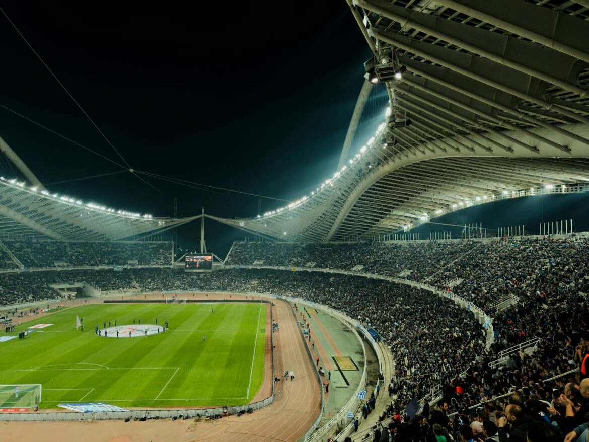 illuminated soccer stadium at night with crowd